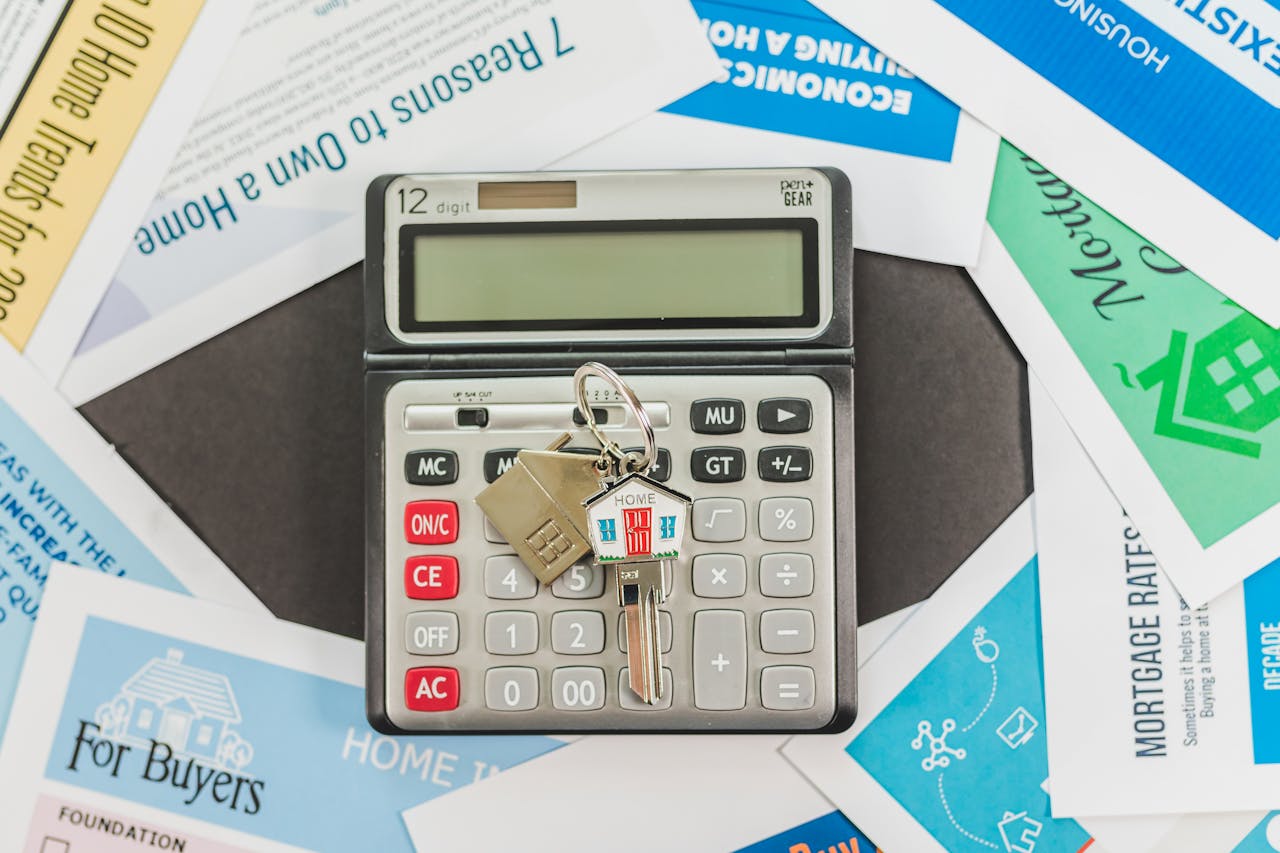 gallery-3 Calculator with keys and real estate documents symbolizes home buying finances.